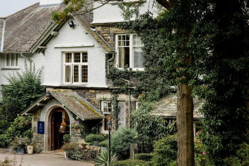 a white house with a stone building at The Ryebeck Hotel in Bowness-on-Windermere