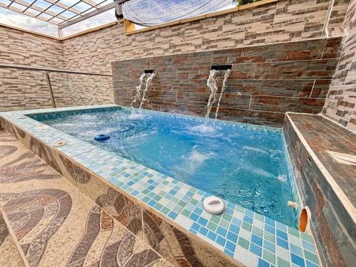 a swimming pool with a fountain in a brick wall at Casa colonial jacuzzi cerca al parque principal in Santa Fe de Antioquia
