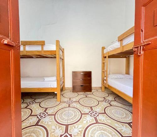 a room with two bunk beds and a carpet at Casa colonial jacuzzi cerca al parque principal in Santa Fe de Antioquia