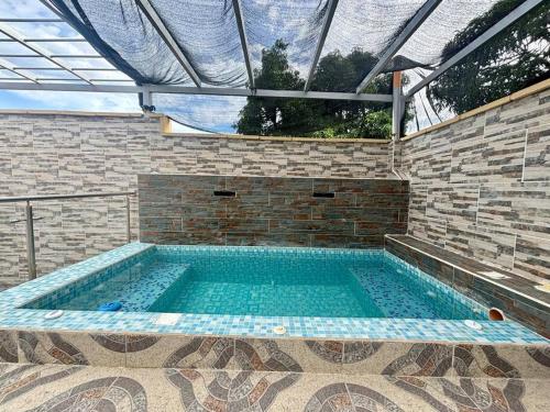 a large swimming pool in a brick building with at Casa colonial jacuzzi cerca al parque principal in Santa Fe de Antioquia