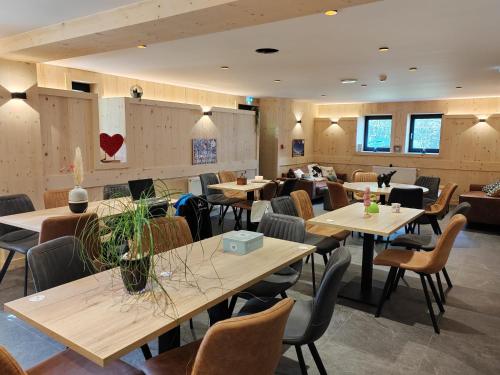a restaurant with tables and chairs in a room at La Ferme du Praz in Les Contamines-Montjoie