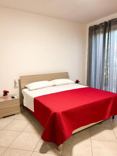 a bedroom with a bed with a red blanket on it at B&B LE LUCI Appartamento al primo piano interno 1 in Vasto