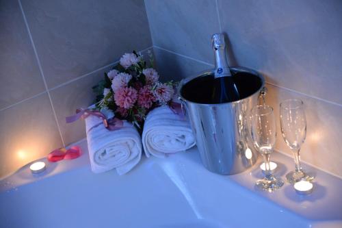 a bathroom sink with a bottle of wine and flowers at Leona apartment in Zemun