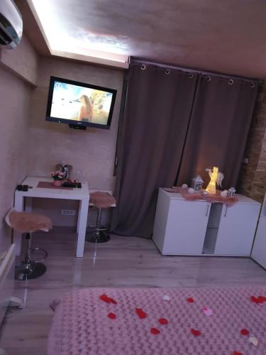 a room with a tv and a table and a table and chairs at Leona apartment in Zemun
