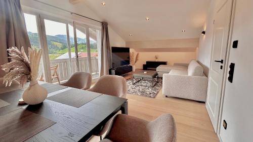 a living room with a table and chairs and a couch at Ferienwohnung "Krainsbergkogel" - Edles Dachgeschossapartment mit Bergblick in Schliersee