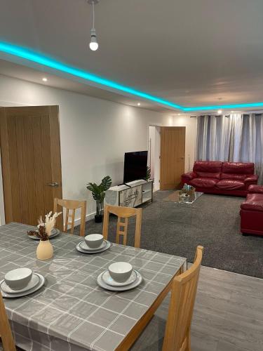 a living room with a table with chairs and a couch at Citrine Suite - Sleeps 8 with Parking in Stoke on Trent