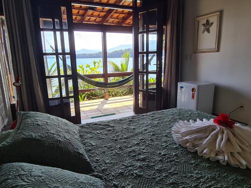 a bedroom with a bed with a view of the ocean at Paraíso Azul Retiro in Abraão