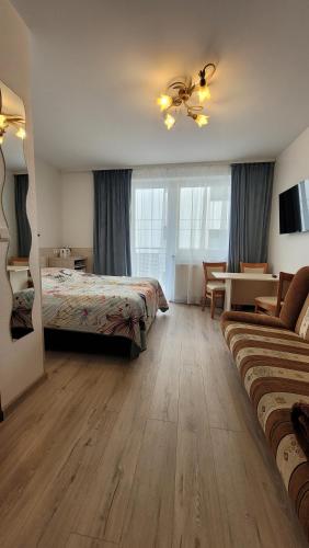 Un dormitorio con dos camas y una mesa y un sofá. en Harpun, en Władysławowo