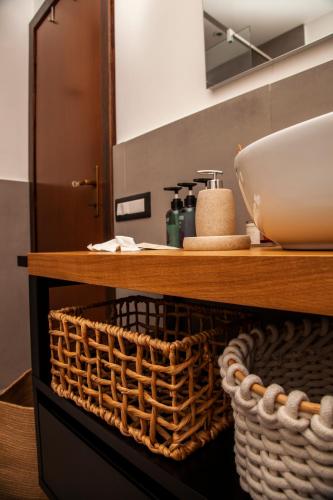 a bathroom with a counter with a sink and a basket at Roussev Apartment - Coastal Gem - Anzio in Anzio