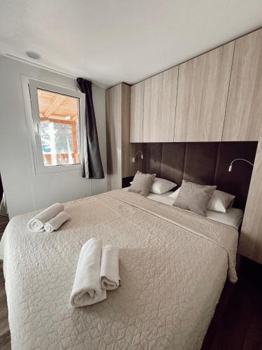 a bedroom with a large bed with towels on it at Dream Escape Mobile Home in Vodice