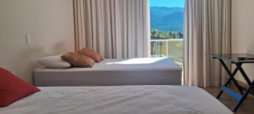ein Hotelzimmer mit zwei Betten und einem Fenster in der Unterkunft Casa Espetacular Piscina Aquecida Ofuro Sauna in Caraguatatuba