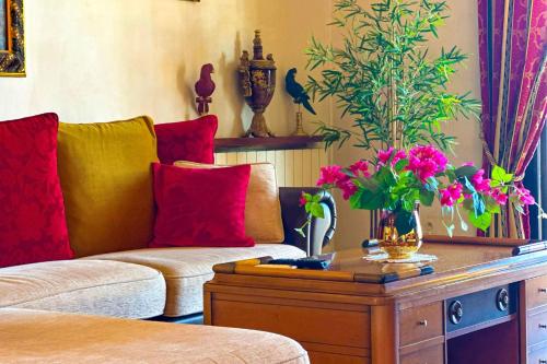 un salon avec un canapé et une table avec des fleurs dans l'établissement Appartement climatisé & wifi 4 pièces 110 m & terrasse vue mer pour 4 pers, à Ajaccio