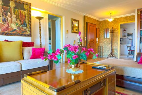 - un salon avec un canapé et des fleurs sur une table dans l'établissement Appartement climatisé & wifi 4 pièces 110 m & terrasse vue mer pour 4 pers, à Ajaccio