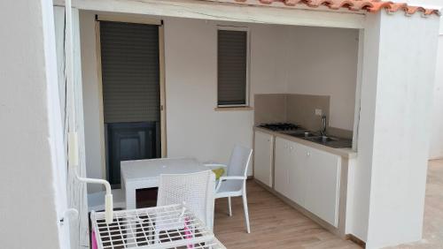 a small kitchen with a table and chairs on a balcony at Giardino dei Baroni house in Marina di Mancaversa