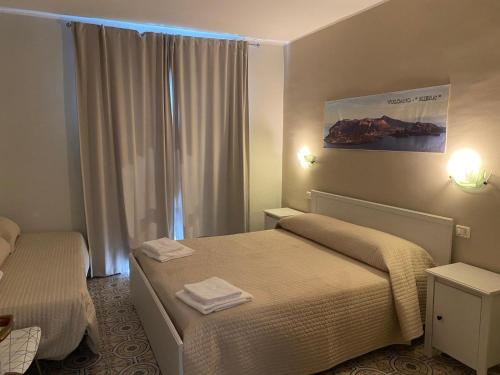 a hotel room with two beds and a window at Phenicusa in Milazzo