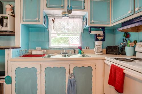 a blue kitchen with a sink and a window at Andover Home Near State Park with Patio and Yard! in Hartstown