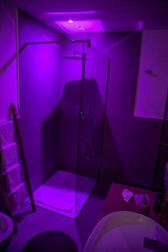 a bathroom with a purple lighted shower and a toilet at Roussev Apartment - Coastal Gem - Anzio in Anzio