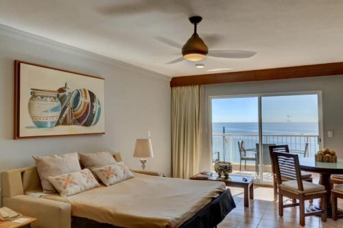 una camera da letto con un letto, un tavolo e un balcone di 2BD Del Palmar: Cabo Luxury Resort a Cabo San Lucas