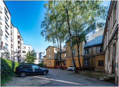 a car parked in a parking lot in front of buildings at Evena Travel Apartment in Rīga