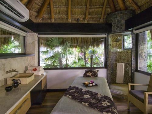 ein Schlafzimmer mit einem Bett und einem Waschbecken in einem Zimmer in der Unterkunft 2BD Del Palmar: Cancun Luxury Resort in Cancún