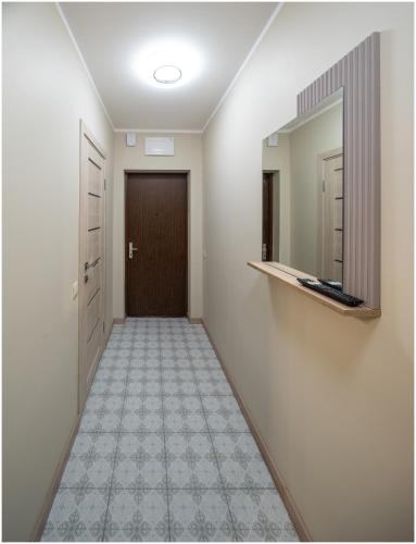 a hallway with a door and a mirror at Evena Travel Apartment in Rīga