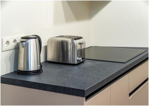 a kitchen counter with two toaster and a toaster at Evena Travel Apartment in Rīga