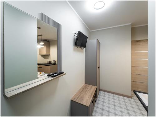 a room with a mirror and a wooden bench at Evena Travel Apartment in Rīga