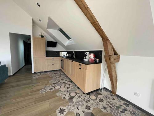 un salon avec une cuisine et un escalier dans l'établissement La grange de Léonie, à Saint-Hilaire-du-Harcouët