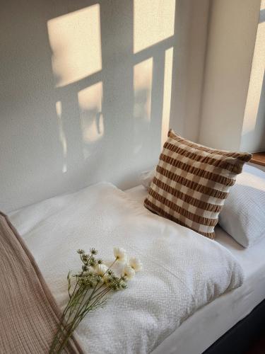 a bed with a pillow and flowers on it at Ferienwohnung am Rathaus in Wiesenbronn