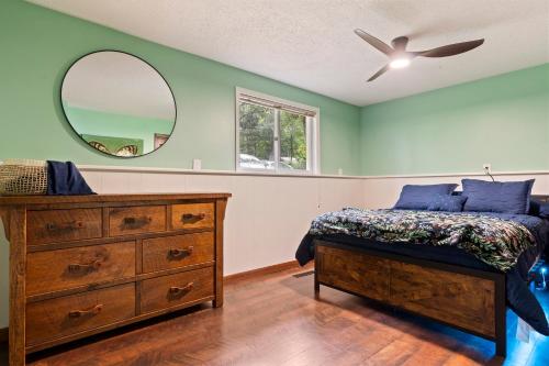 a bedroom with a bed and a dresser and a mirror at Large Home with lake views and space to entertain friends in Cross Lake