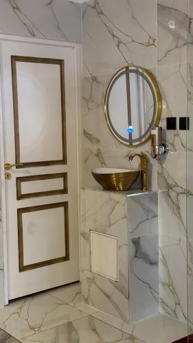 une salle de bain avec un lavabo et un miroir dans l'établissement Le Palais Du Khalif, à Fabrègues
