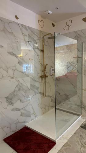 une douche avec une porte vitrée dans une salle de bain dans l'établissement Le Palais Du Khalif, à Fabrègues