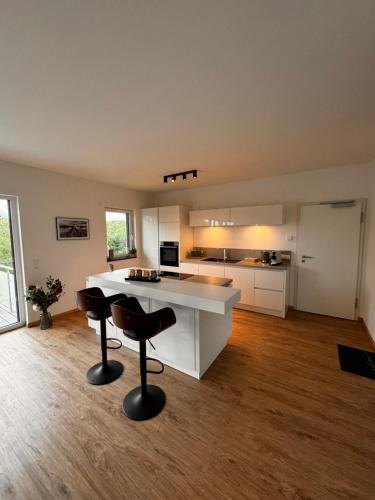 a kitchen with a counter and two chairs in a room at Traumhafter Ausblick, modern mit Komfort und Stil in Hardert