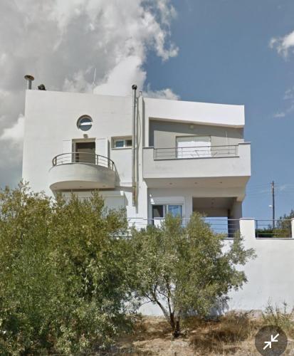 a white building with a balcony on the side of it at Sunset hellen in Katsíkia
