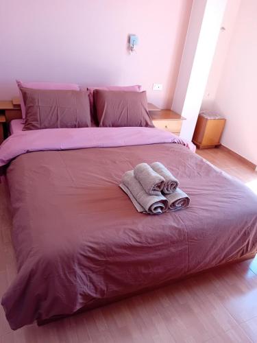 a large bed with two towels on top of it at Sunset hellen in Katsíkia