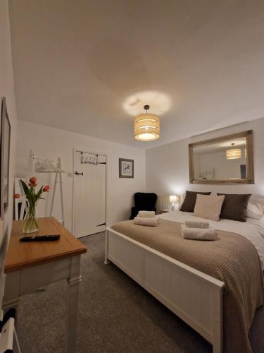 a bedroom with a bed and a table and a mirror at Black Cat Cottage - Central Pickering Cottage in Pickering