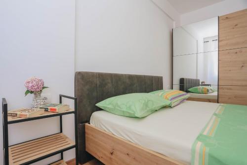 a bedroom with a bed with a wooden headboard at Toplish 27 in Budva