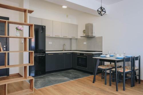 a kitchen with black appliances and a table with chairs at Toplish 27 in Budva