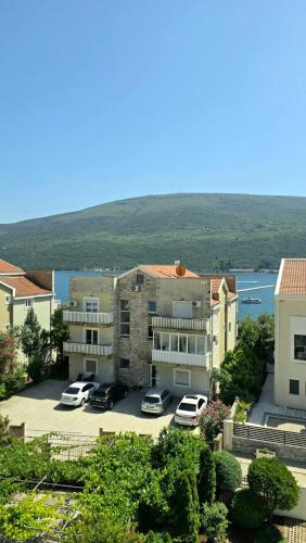 a group of buildings with cars parked in a parking lot at Sunny Portside Apartment in Ðenovići