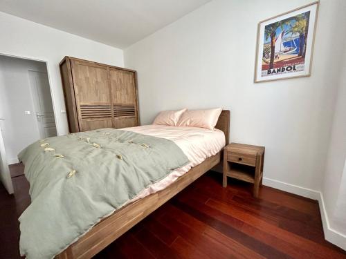 ein kleines Schlafzimmer mit einem Bett und einem Kopfteil aus Holz in der Unterkunft La maison du papé classé 3 etoiles in Bandol