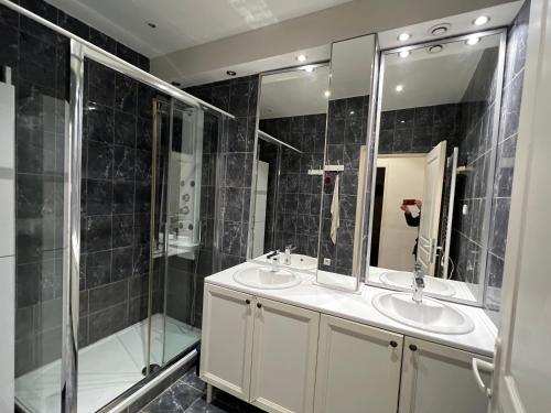 ein schwarz gefliestes Bad mit 2 Waschbecken und einer Dusche in der Unterkunft La maison du papé classé 3 etoiles in Bandol