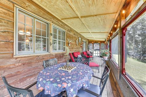 a dining room with a table and chairs on a porch at Charming Parsons Cabin with Grill on the Cheat River in Parsons