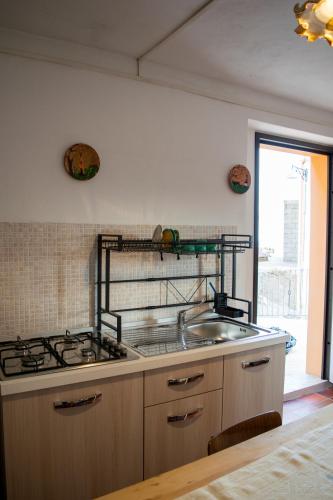 a kitchen with a sink and a stove at S' APPosenteddu in Baunei