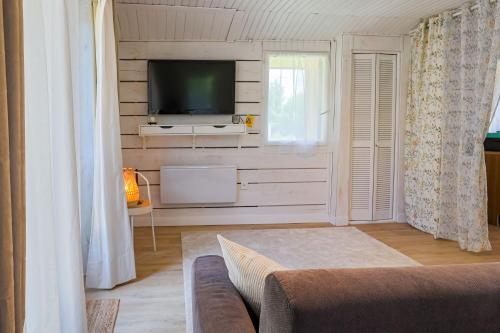 a living room with a tv and a couch at La parenthèse chambonnaise - chalet cosy, WIFI in Le Chambon-sur-Lignon