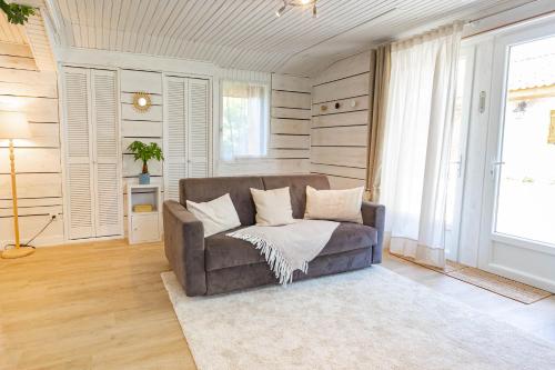 a living room with a couch and a window at La parenthèse chambonnaise - chalet cosy, WIFI in Le Chambon-sur-Lignon