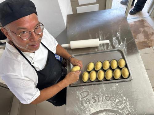 a man in a kitchen with a tray of food at Masseria Donna Menga - The Leading Hotels of the World in Torre Lapillo