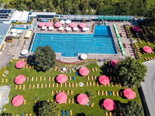 an aerial view of a pool with pink umbrellas at Alping Apartments in Brunico