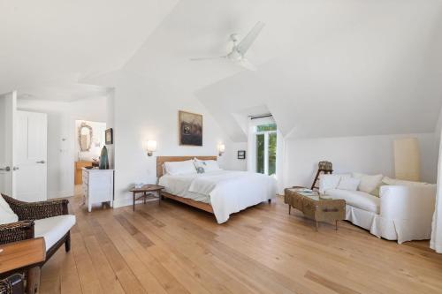 Un dormitorio blanco con una cama y un sofá. en Away in the County-Sandbanks Pec, en Cherry Valley