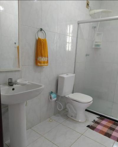 a white bathroom with a toilet and a sink at Flor de Lis in Salvador
