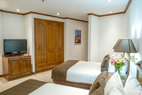 a hotel room with a bed and a tv at Hotel Bogotá Regency Usaquén in Bogotá